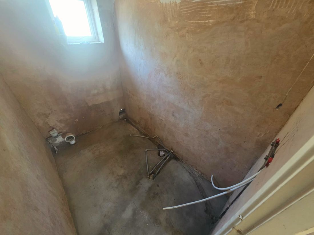 Bathroom stripped back to bare plaster and pipework before renovation