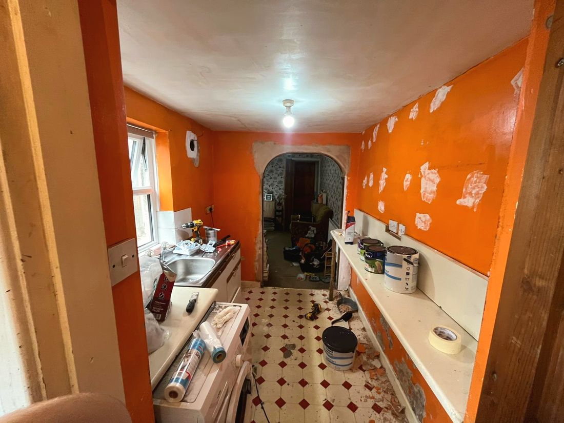 Tired kitchen mid-strip with orange walls before redecoration