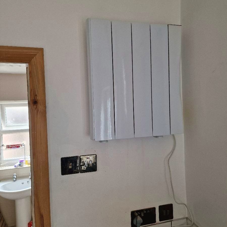 A wall-mounted electric panel heater fitted and connected
